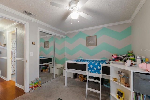 bedroom with crown molding, a textured ceiling, a closet, and a ceiling fan