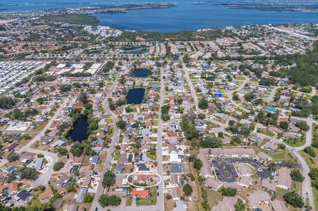aerial view of property and surrounding area with a large body of water and nearby suburban area