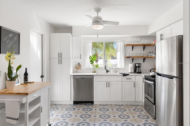 6442 Colonial Dr, Sarasota, FL 34231 - kitchen with appliances with stainless steel finishes, open shelves, a sink, white cabinets, and a ceiling fan