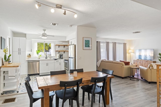 6442 Colonial Dr, Sarasota, FL 34231 - dining space featuring light wood-type flooring, ceiling fan, and a textured ceiling