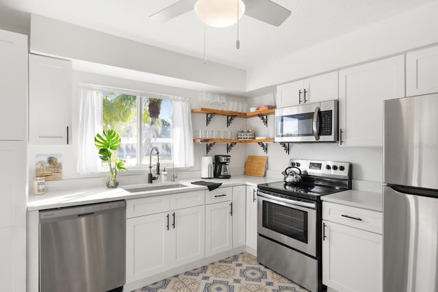 6442 Colonial Dr, Sarasota, FL 34231 - kitchen with stainless steel appliances, a sink, light countertops, and white cabinets