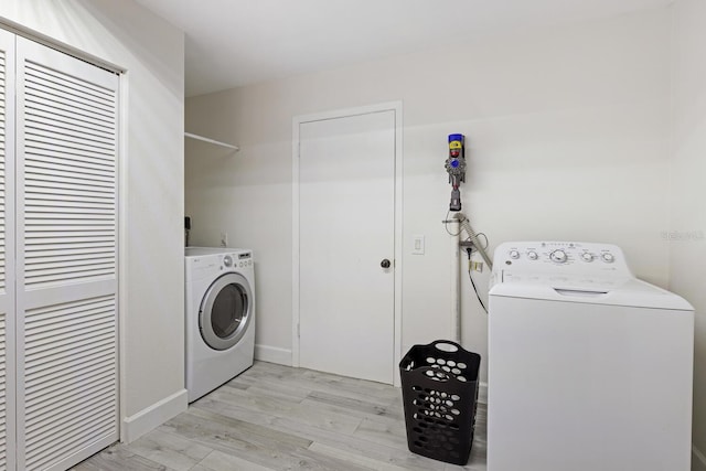 6442 Colonial Dr, Sarasota, FL 34231 - laundry area featuring light wood finished floors and washing machine and dryer