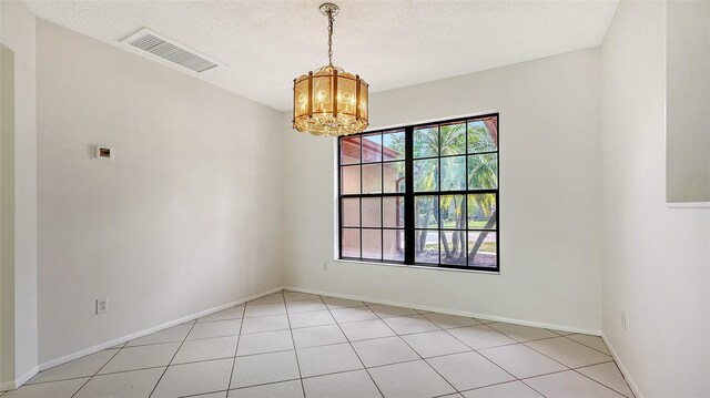 5004 32nd St E, Bradenton, FL 34203 - unfurnished room featuring a chandelier, tile patterned floors, and baseboards