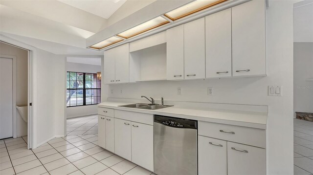 5004 32nd St E, Bradenton, FL 34203 - kitchen with stainless steel dishwasher, a sink, light countertops, light tile patterned floors, and white cabinets