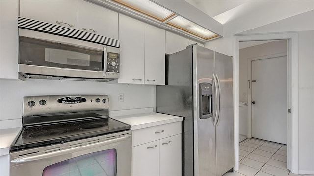 5004 32nd St E, Bradenton, FL 34203 - kitchen with appliances with stainless steel finishes, light countertops, light tile patterned flooring, and white cabinetry