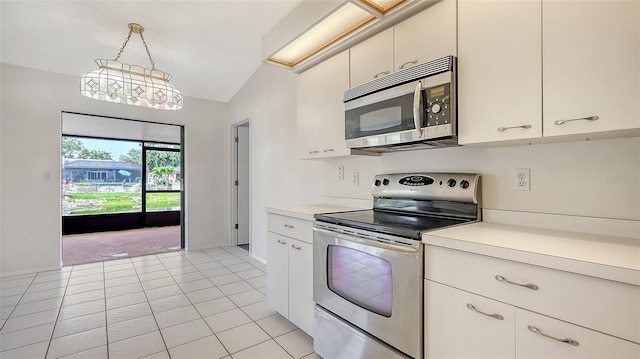 5004 32nd St E, Bradenton, FL 34203 - kitchen with stainless steel appliances, light countertops, lofted ceiling, hanging light fixtures, and light tile patterned floors