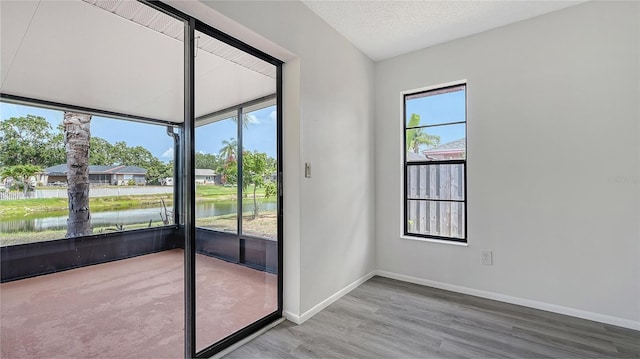 5004 32nd St E, Bradenton, FL 34203 - doorway with a water view, wood finished floors, and baseboards