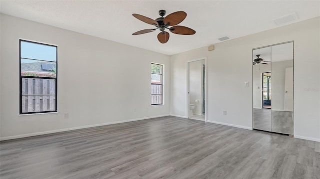 5004 32nd St E, Bradenton, FL 34203 - unfurnished bedroom featuring multiple windows, wood finished floors, baseboards, and ensuite bath
