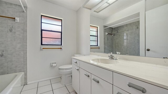 5004 32nd St E, Bradenton, FL 34203 - bathroom featuring tile patterned flooring, toilet, baseboards, vanity, and tiled shower / bath combo