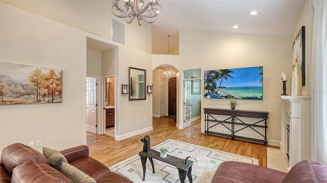 1934 Bougainvillea St, Sarasota, FL 34239 - living room featuring a chandelier, arched walkways, light wood-style flooring, recessed lighting, and a towering ceiling