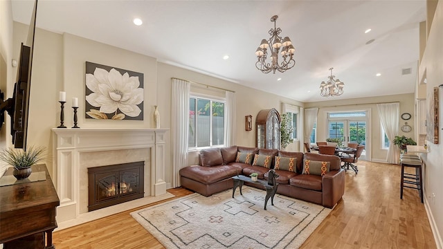 1934 Bougainvillea St, Sarasota, FL 34239 - living area with a chandelier, healthy amount of natural light, light wood-type flooring, a high end fireplace, and recessed lighting