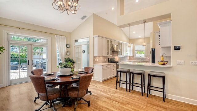 1934 Bougainvillea St, Sarasota, FL 34239 - dining area featuring light wood-style floors, a chandelier, french doors, high vaulted ceiling, and baseboards