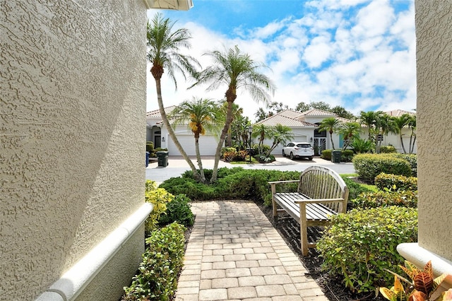 view of patio / terrace with concrete driveway, a garage, and a residential view
