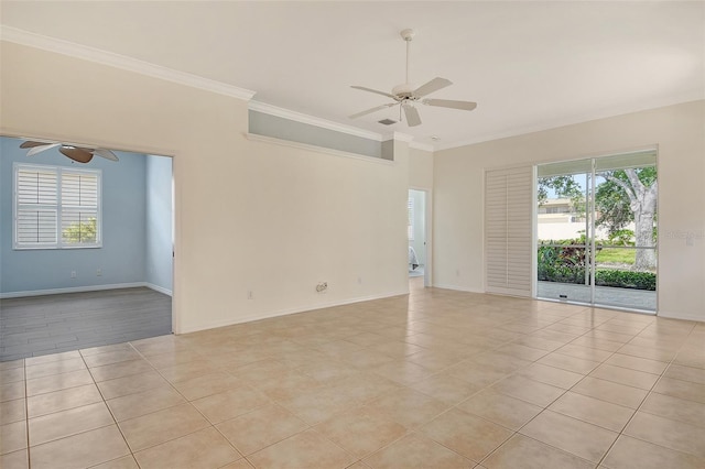 empty room with ceiling fan, crown molding, light tile patterned floors, and baseboards