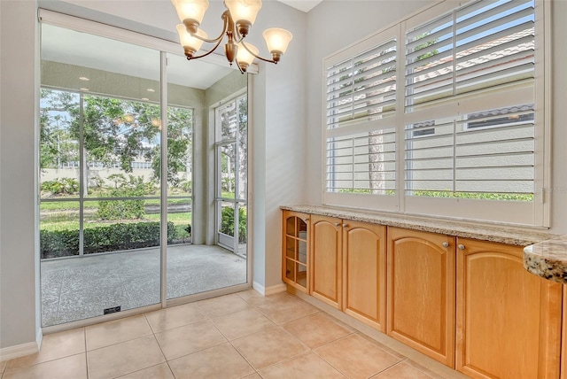 bathroom featuring baseboards, tile patterned floors, and a chandelier