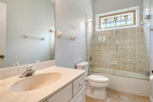 full bath with tile patterned floors, vanity, toilet, and shower / bath combination with glass door