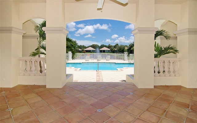 community pool featuring a patio, a ceiling fan, and fence