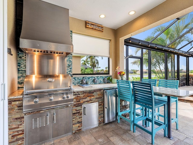 view of patio / terrace featuring exterior kitchen, grilling area, and a lanai