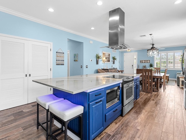 kitchen featuring blue cabinets, appliances with stainless steel finishes, range hood, dark wood finished floors, and recessed lighting