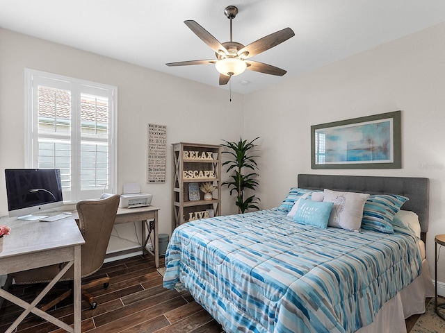 bedroom with wood finished floors, a desk, baseboards, and a ceiling fan