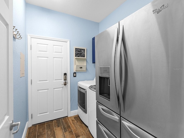 laundry area featuring washing machine and clothes dryer, dark wood-style flooring, and baseboards