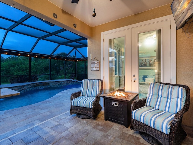 view of patio / terrace featuring a fire pit, an outdoor pool, and a lanai