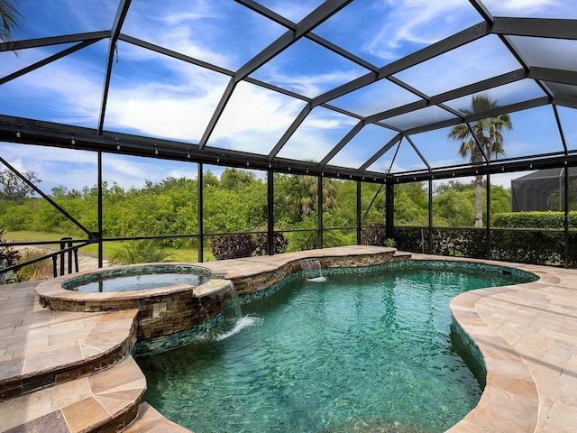 view of pool with a pool with connected hot tub, glass enclosure, and a patio