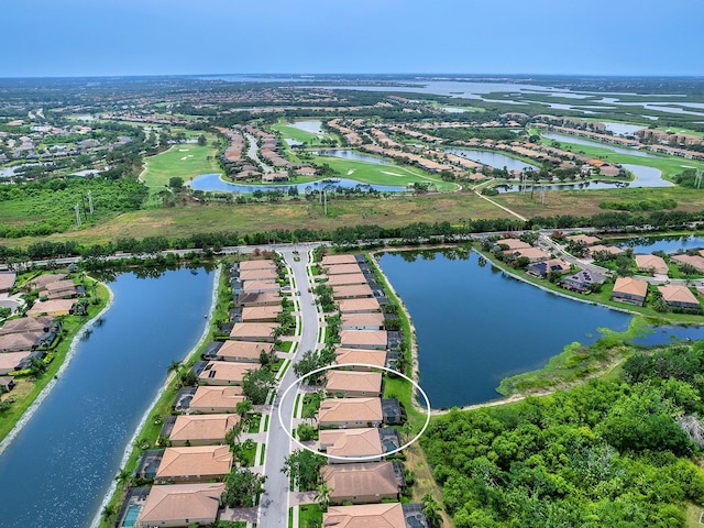 aerial view of residential area featuring a nearby body of water and a local golf course