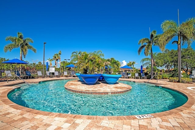 community pool with a patio and fence