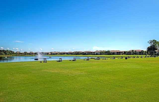 view of community featuring a water view and a yard