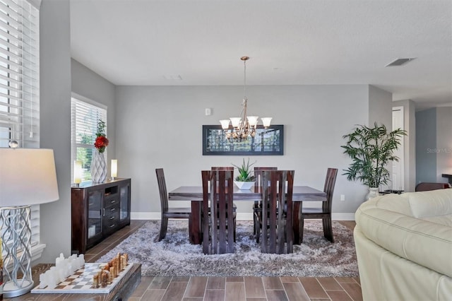 3430 77th St W Unit 103, Bradenton, FL 34209 - dining area with a chandelier, wood finish floors, and baseboards