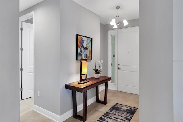 3430 77th St W Unit 103, Bradenton, FL 34209 - foyer entrance featuring a chandelier, light tile patterned floors, and baseboards