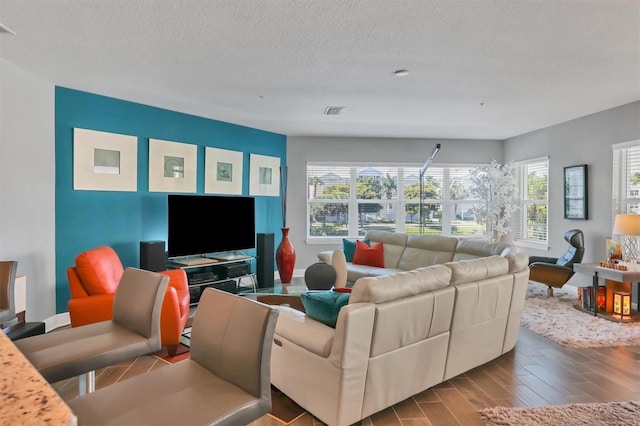 3430 77th St W Unit 103, Bradenton, FL 34209 - living room featuring healthy amount of natural light, a textured ceiling, wood finished floors, and baseboards