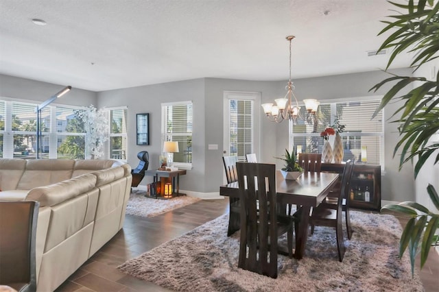 3430 77th St W Unit 103, Bradenton, FL 34209 - dining space featuring dark wood finished floors, a chandelier, and baseboards