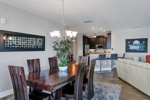 3430 77th St W Unit 103, Bradenton, FL 34209 - dining space with dark wood finished floors, a chandelier, baseboards, and recessed lighting