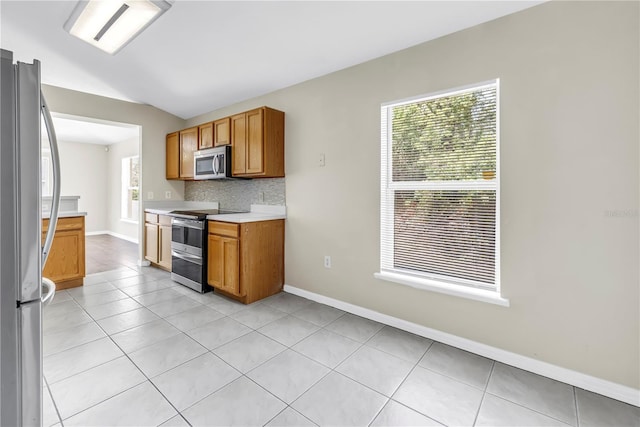 2499 Trimble Ave, North Port, FL 34288 - kitchen featuring appliances with stainless steel finishes, light countertops, light tile patterned floors, decorative backsplash, and baseboards
