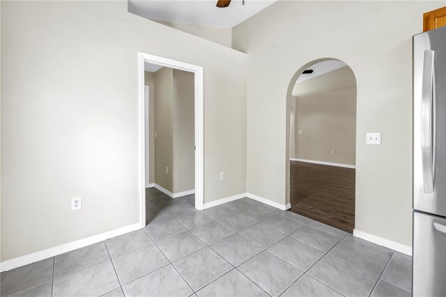 2499 Trimble Ave, North Port, FL 34288 - spare room featuring arched walkways, light tile patterned floors, a ceiling fan, and baseboards