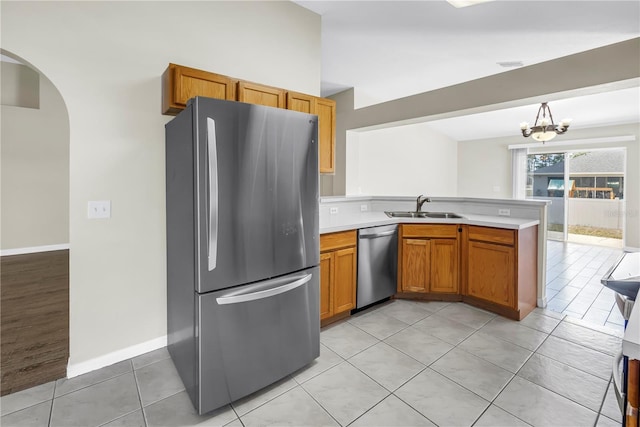 2499 Trimble Ave, North Port, FL 34288 - kitchen with appliances with stainless steel finishes, a sink, a peninsula, arched walkways, and light countertops