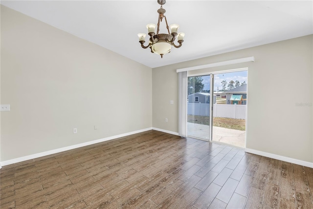 2499 Trimble Ave, North Port, FL 34288 - spare room featuring a chandelier, wood finished floors, and baseboards