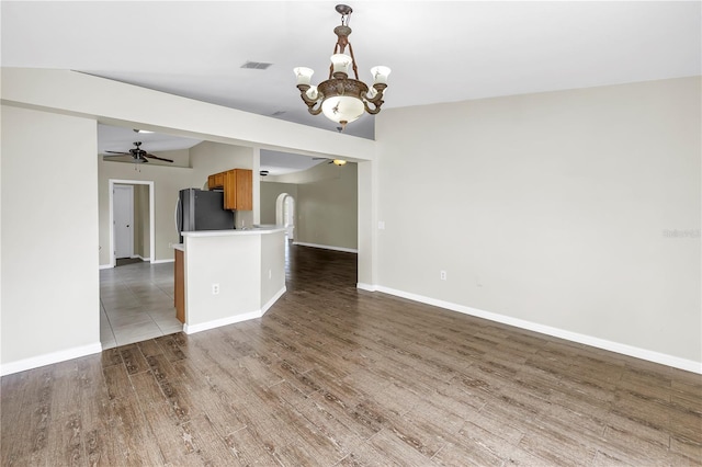 2499 Trimble Ave, North Port, FL 34288 - empty room featuring ceiling fan, a chandelier, wood finished floors, and baseboards