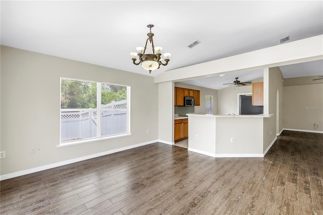 2499 Trimble Ave, North Port, FL 34288 - unfurnished living room featuring a chandelier, dark wood-style floors, vaulted ceiling, and baseboards