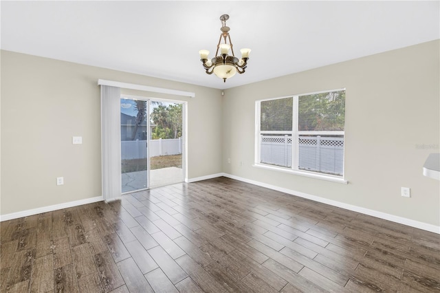 2499 Trimble Ave, North Port, FL 34288 - unfurnished room with a chandelier, dark wood-style floors, and baseboards