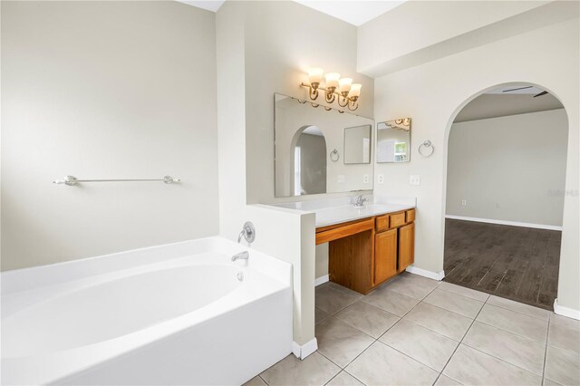 2499 Trimble Ave, North Port, FL 34288 - full bathroom featuring a bath, vanity, tile patterned flooring, a chandelier, and baseboards