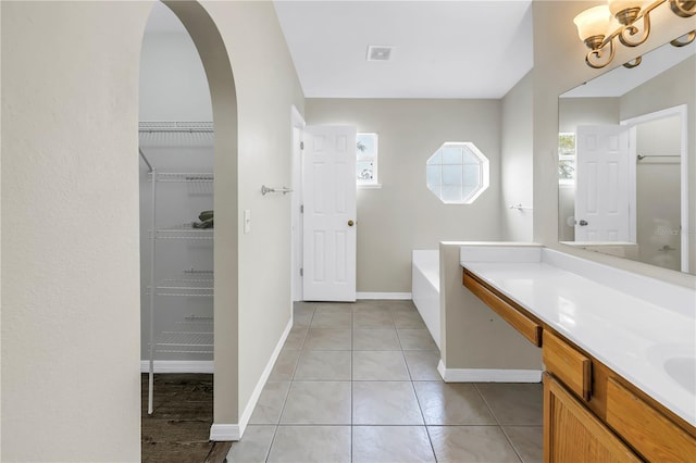 2499 Trimble Ave, North Port, FL 34288 - full bathroom with vanity, baseboards, a bath, tile patterned flooring, and a spacious closet