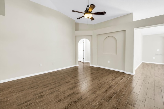 2499 Trimble Ave, North Port, FL 34288 - empty room featuring a ceiling fan, lofted ceiling, dark wood-type flooring, arched walkways, and baseboards