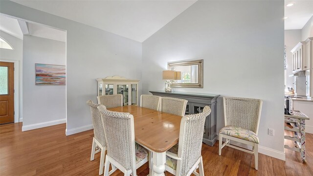 dining area featuring baseboards, wood finished floors, high vaulted ceiling, and recessed lighting