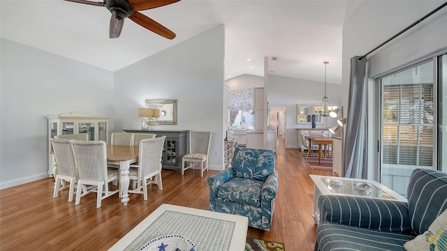 living area featuring ceiling fan, a chandelier, wood finished floors, baseboards, and high vaulted ceiling