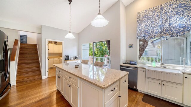 kitchen with dishwasher, wood finished floors, refrigerator with ice dispenser, high vaulted ceiling, and decorative light fixtures