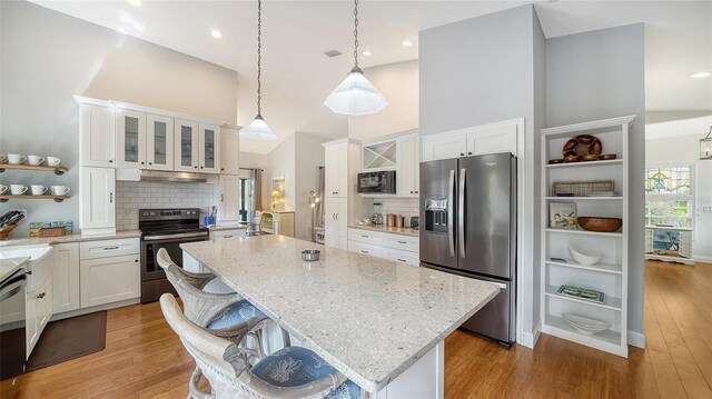 kitchen featuring stainless steel appliances, open shelves, high vaulted ceiling, white cabinetry, and tasteful backsplash