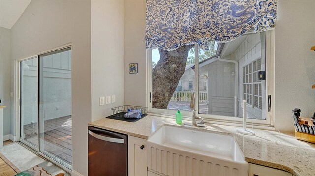 kitchen with dishwasher, light stone countertops, and white cabinets